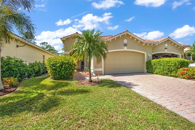 mediterranean / spanish house featuring a front yard and a garage