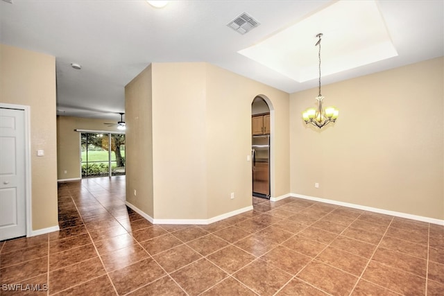 unfurnished room with dark tile patterned flooring and ceiling fan with notable chandelier