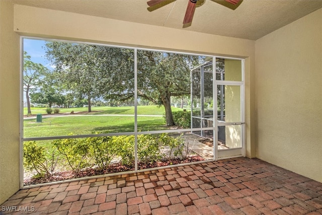 unfurnished sunroom featuring ceiling fan