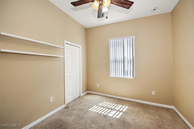 unfurnished bedroom featuring ceiling fan, a closet, and light carpet