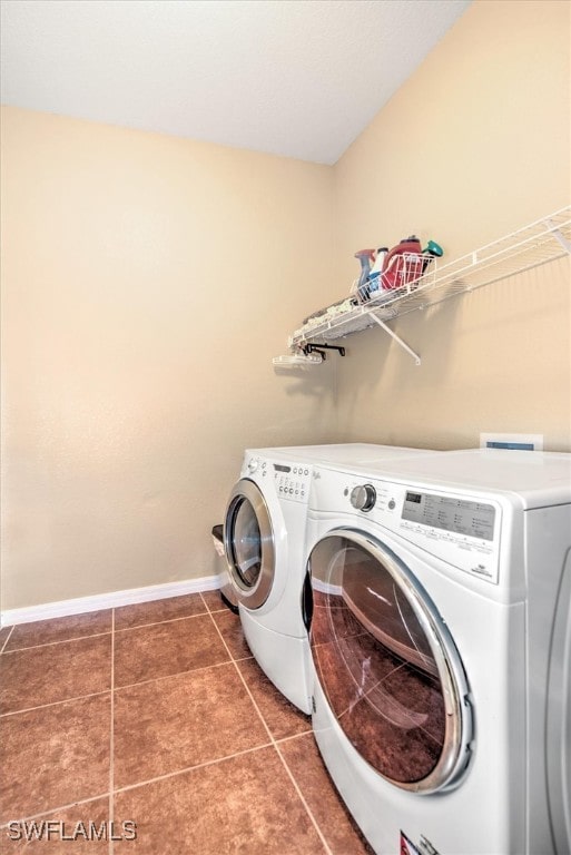 laundry room featuring dark tile patterned flooring and washing machine and clothes dryer