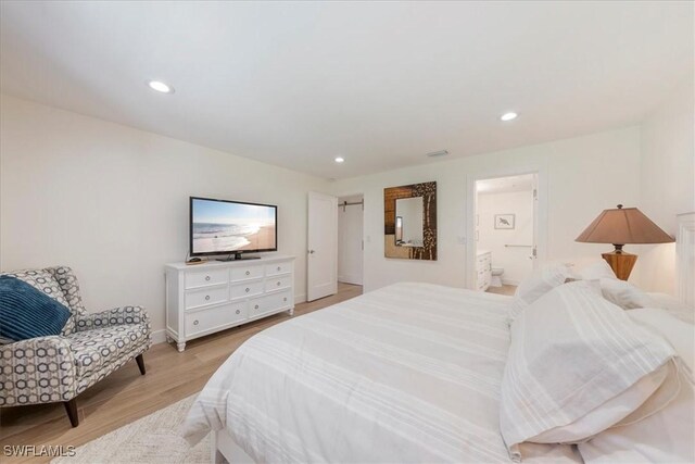 bedroom featuring ensuite bath and light hardwood / wood-style flooring