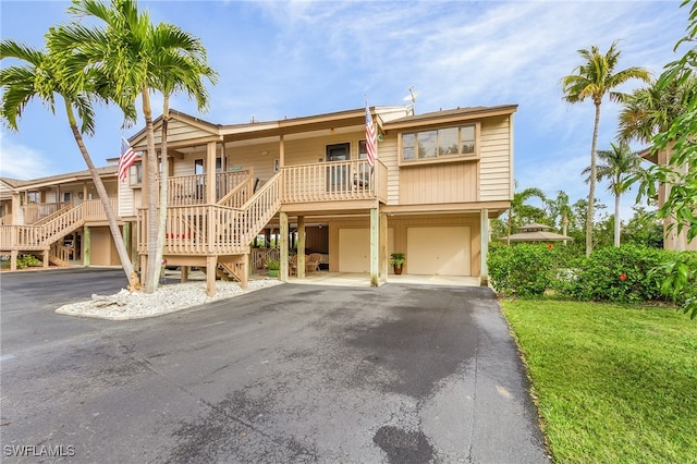 view of front of property featuring a garage, a porch, and a front lawn