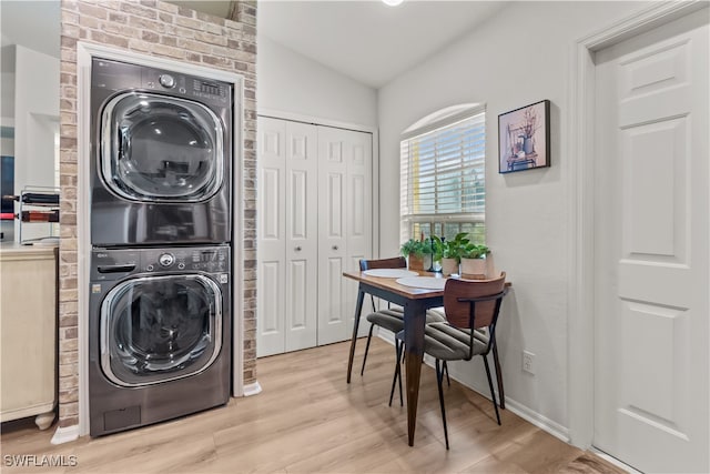 clothes washing area with light hardwood / wood-style flooring and stacked washer and clothes dryer