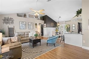 living room featuring wood-type flooring, vaulted ceiling, and ceiling fan