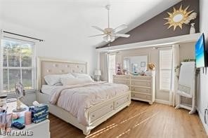 bedroom with ceiling fan, lofted ceiling, and hardwood / wood-style floors