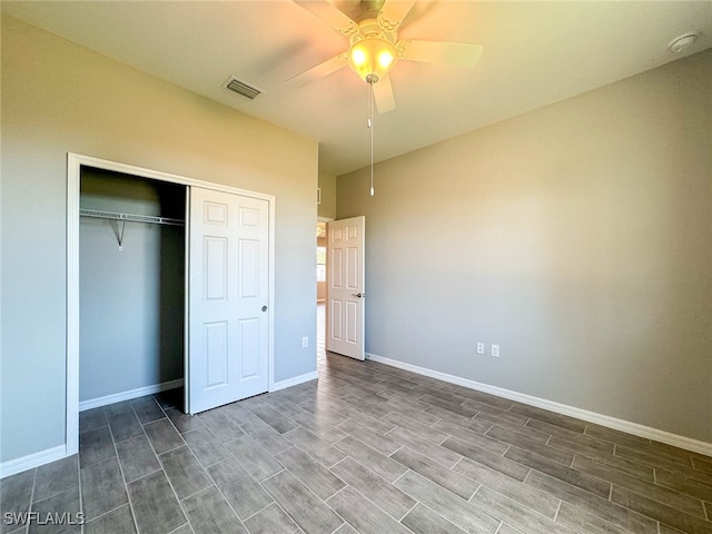 unfurnished bedroom with dark wood-type flooring, ceiling fan, and a closet