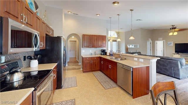 kitchen featuring pendant lighting, sink, backsplash, appliances with stainless steel finishes, and ceiling fan