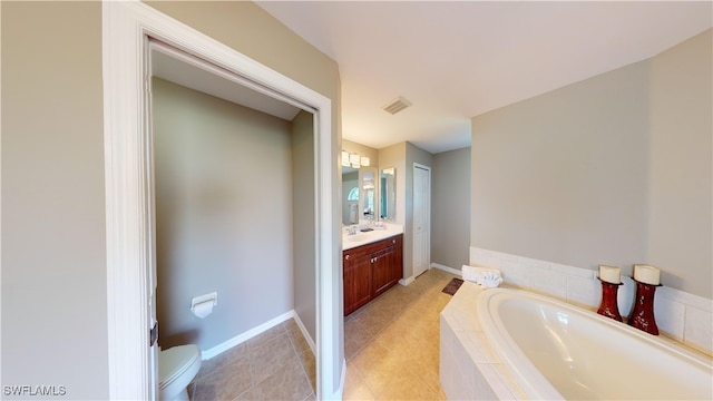 bathroom featuring tiled tub, vanity, toilet, and tile patterned floors