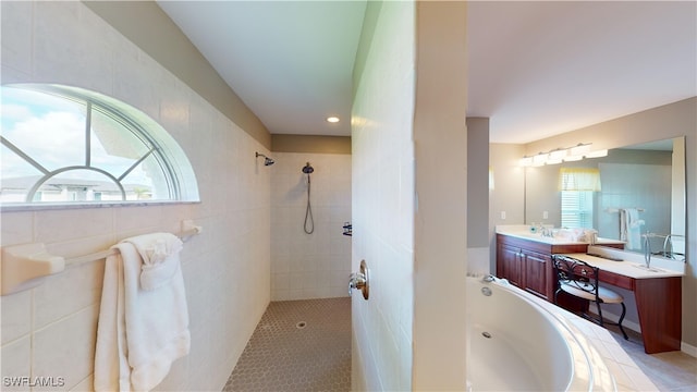 bathroom featuring plus walk in shower, tile walls, tile patterned flooring, and vanity