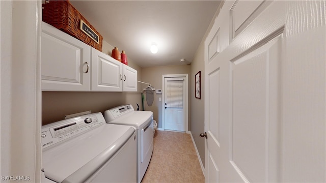 washroom featuring washer and clothes dryer, cabinets, and light tile patterned floors