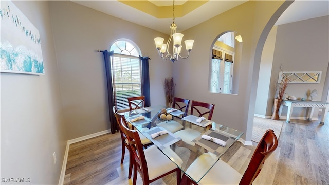 dining area with wood-type flooring and a chandelier