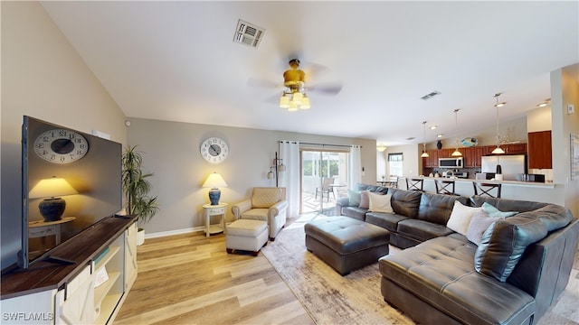 living room with ceiling fan, light hardwood / wood-style flooring, and vaulted ceiling