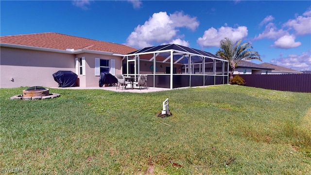 back of property featuring a fire pit, a patio, a lawn, and a lanai