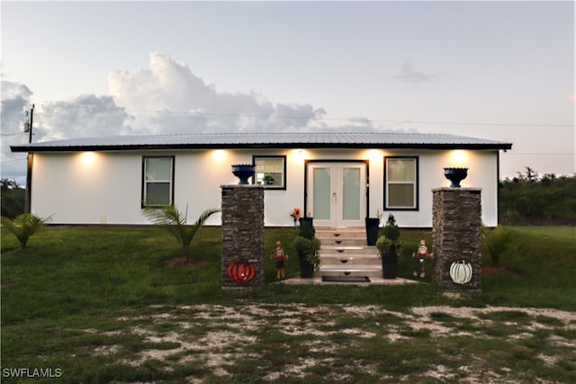 view of front facade featuring a front lawn and french doors