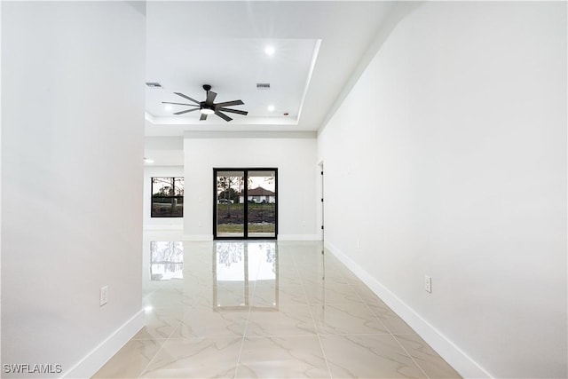 unfurnished room with a tray ceiling and ceiling fan