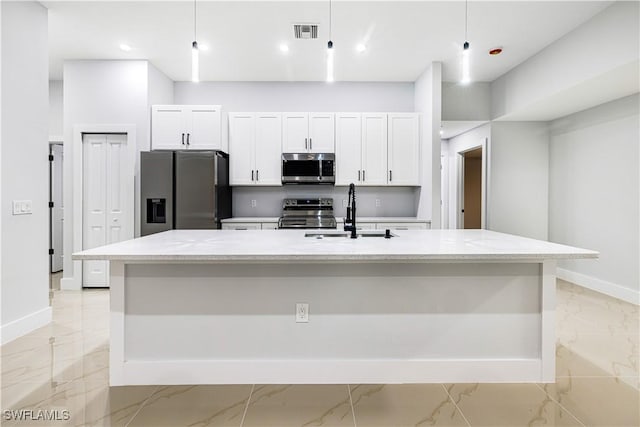 kitchen with sink, an island with sink, pendant lighting, and appliances with stainless steel finishes