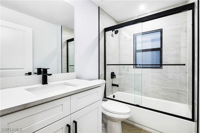 full bathroom featuring vanity, toilet, and shower / bath combination with glass door