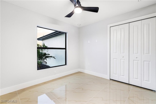 unfurnished bedroom with ceiling fan and a closet