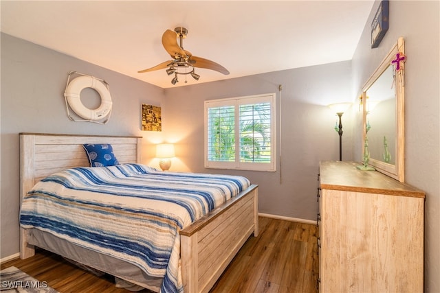 bedroom with dark hardwood / wood-style floors and ceiling fan