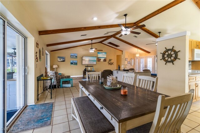 dining space featuring french doors, lofted ceiling with beams, and light tile patterned flooring