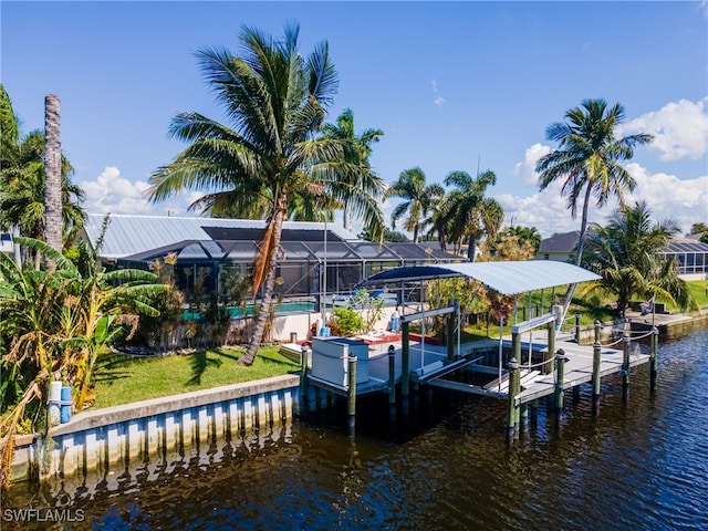 view of dock with a lawn, a water view, and glass enclosure