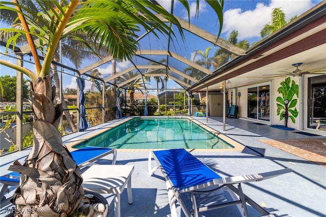 view of pool featuring ceiling fan, glass enclosure, and a patio area