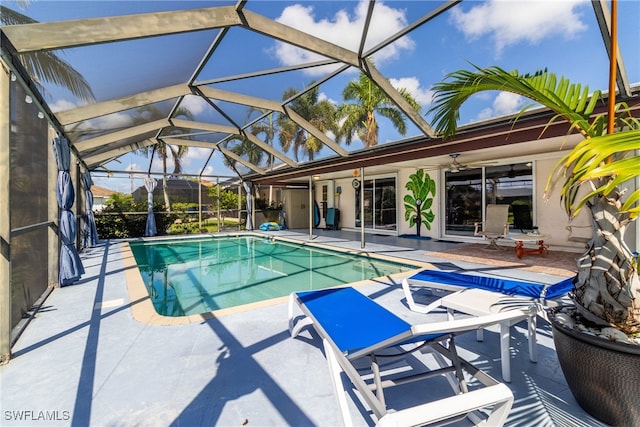 view of swimming pool with a lanai, a patio area, and ceiling fan