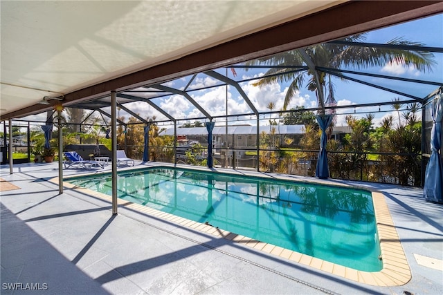 view of pool with a patio area and glass enclosure