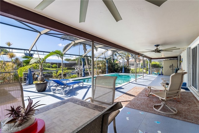 view of pool featuring a patio area, glass enclosure, and ceiling fan