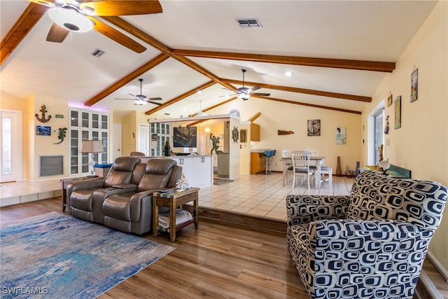 living room featuring hardwood / wood-style floors, vaulted ceiling with beams, and ceiling fan