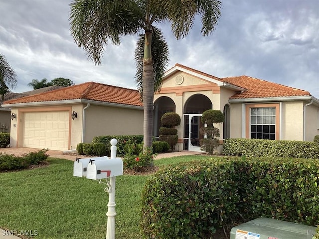 mediterranean / spanish-style home featuring a garage and a front lawn