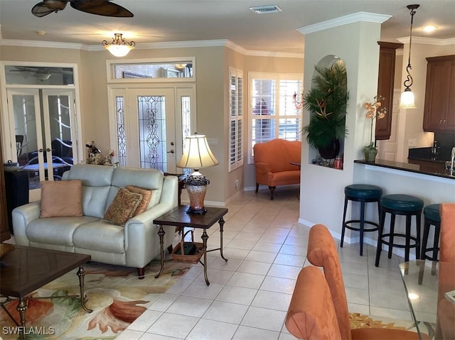 tiled living room featuring crown molding and ceiling fan