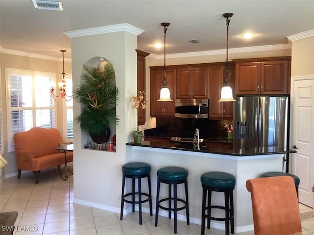 kitchen with hanging light fixtures, kitchen peninsula, a kitchen bar, light tile patterned floors, and appliances with stainless steel finishes