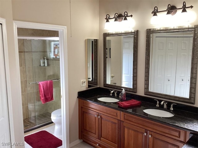 bathroom featuring tile patterned floors, a shower with door, vanity, and toilet