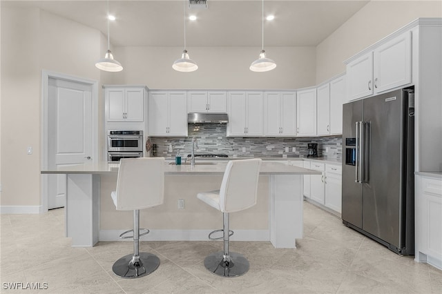 kitchen featuring white cabinetry, stainless steel appliances, pendant lighting, a kitchen island with sink, and a breakfast bar