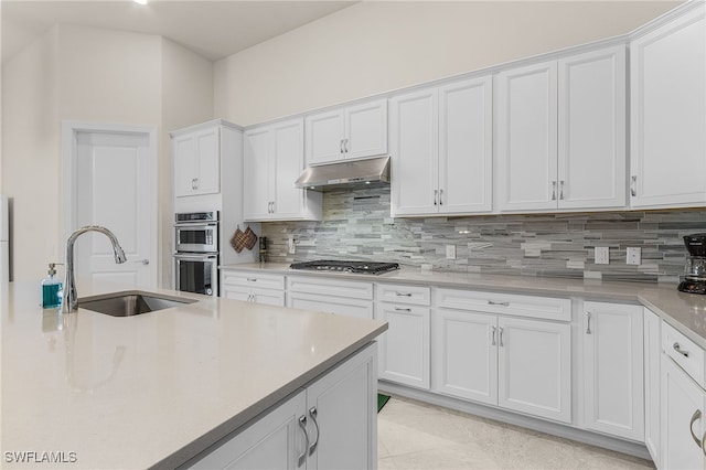 kitchen featuring tasteful backsplash, white cabinetry, sink, and stainless steel appliances