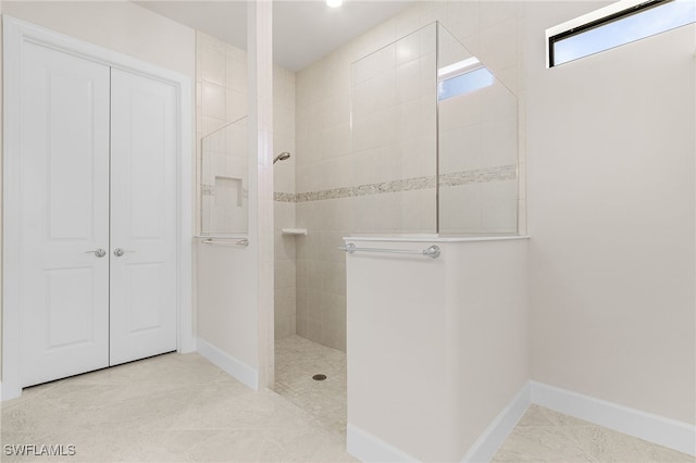 bathroom featuring tile patterned flooring and a tile shower