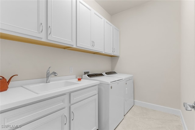 laundry area featuring separate washer and dryer, sink, light tile patterned flooring, and cabinets