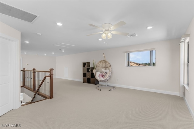 interior space with ceiling fan and light colored carpet