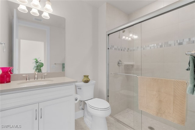 bathroom featuring tile patterned flooring, vanity, toilet, and a shower with door