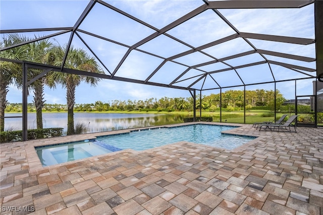 view of pool featuring glass enclosure, a water view, and a patio