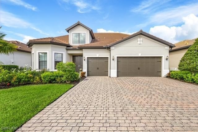 view of front of property with a garage and a front lawn