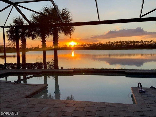 dock area featuring a water view, glass enclosure, and a patio area