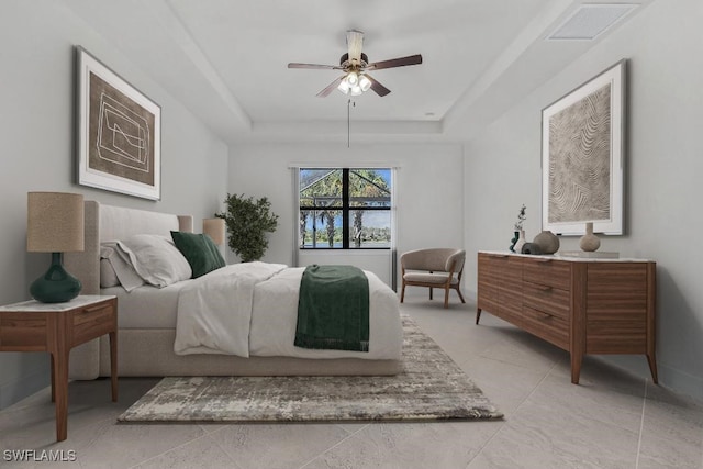 bedroom featuring a tray ceiling, ceiling fan, and light tile patterned floors