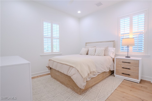 bedroom featuring light hardwood / wood-style flooring and multiple windows