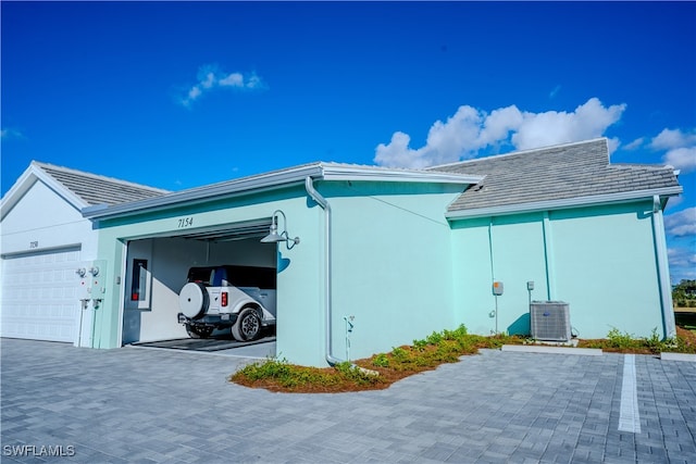 view of home's exterior featuring a garage and central AC