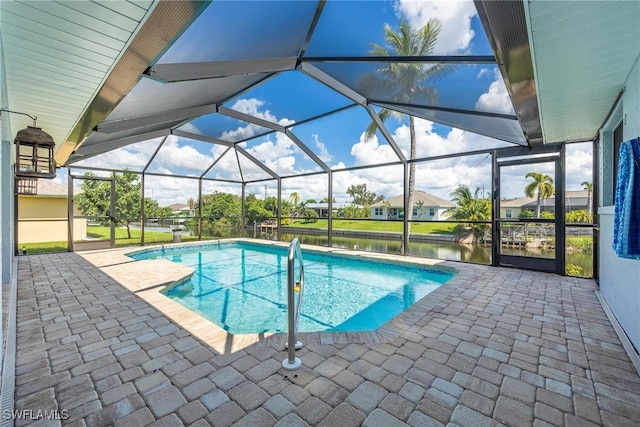 view of swimming pool with a patio, glass enclosure, and a water view