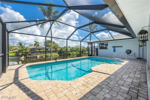 view of pool with a patio, glass enclosure, and a water view