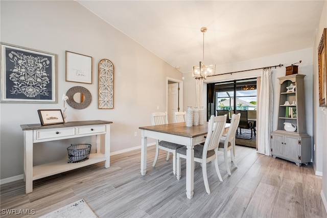 dining area with an inviting chandelier, light hardwood / wood-style flooring, and lofted ceiling